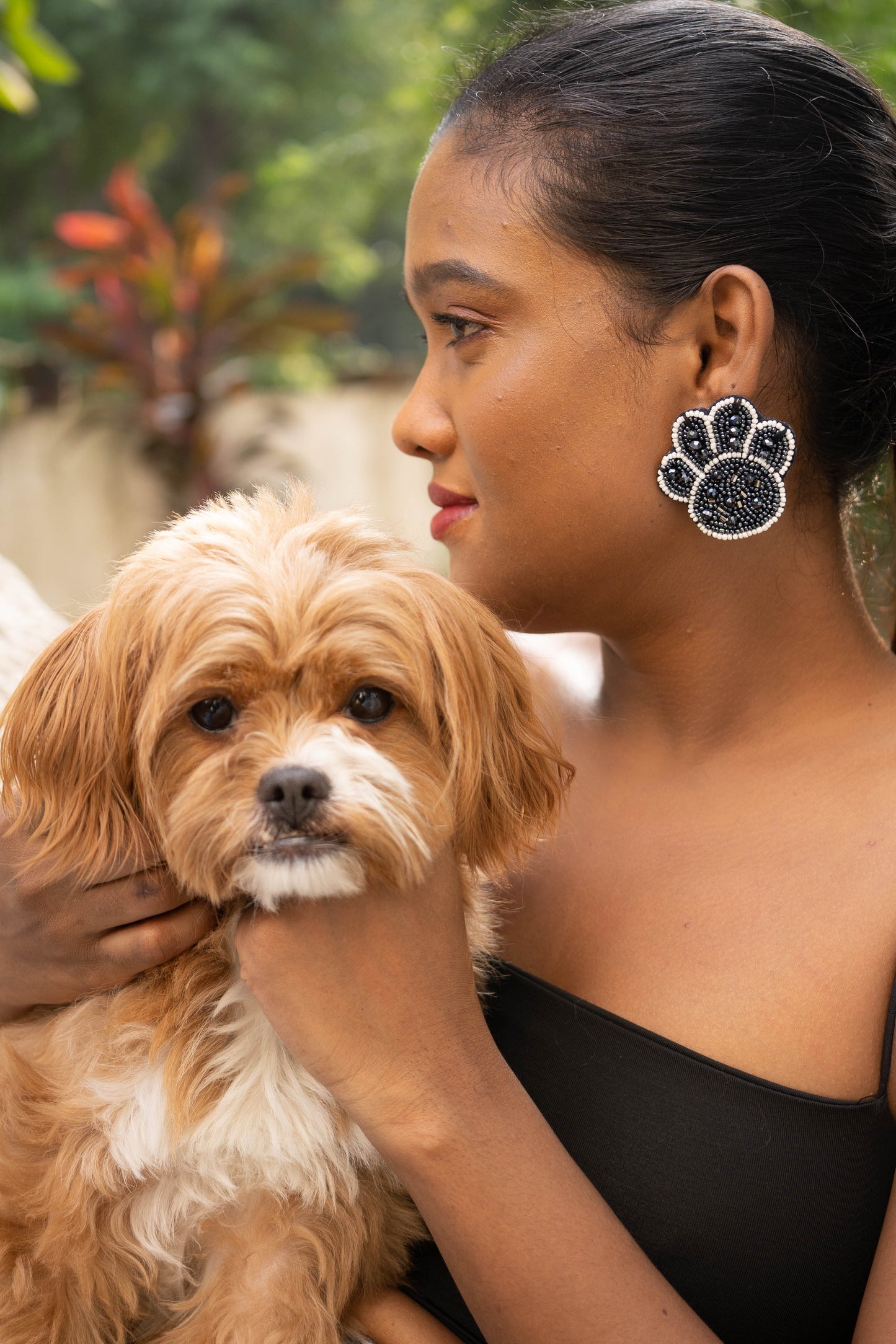 Woman petting a small dog outdoors with blurred background